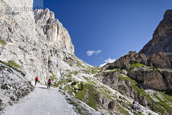 Wanderer beim Aufstieg zum Kesselkogel oberhalb vom Rifugio Gardecia  hinten der Rosengarten und das Rifugio Preuss  Trentino  Italien  Europa