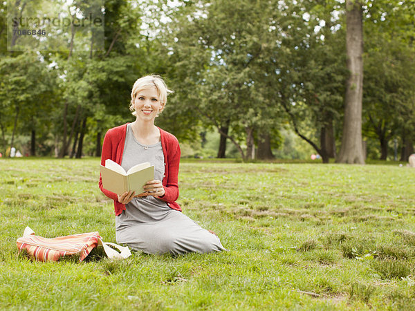 sitzend  Frau  Buch  halten  Gras  Taschenbuch