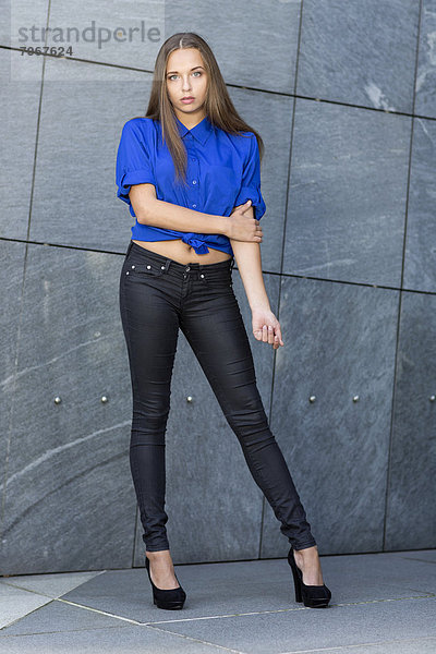 Pumps hoch oben junge Frau junge Frauen Stein Pose grau Wand schwarz frontal blau Jeans Kleidung
