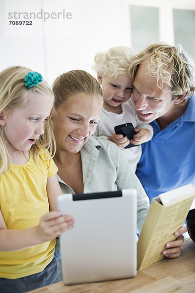 Familie mit digitaler Tablette für die Kuchenzubereitung in der Küche