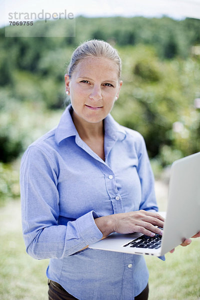 Portrait einer selbstbewussten Geschäftsfrau mit Laptop