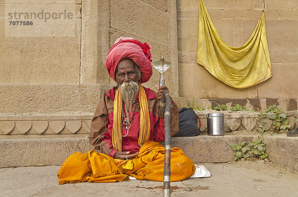 Sadhu  heiliger Mann  sitzt an einem der Ghats der historischen Stadt Varanasi  Indien  Asien
