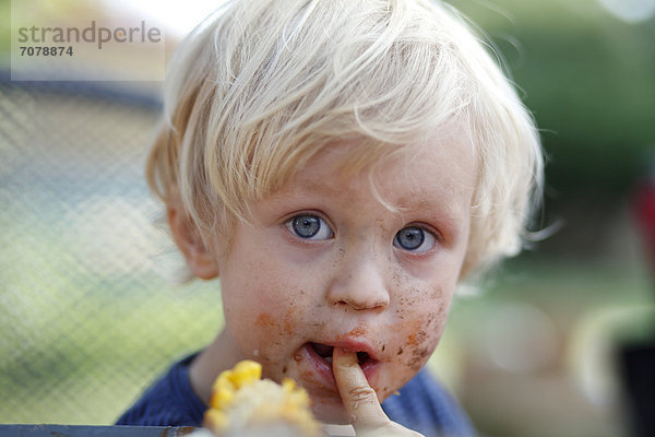 Kleiner Junge mit schokoladenverschmiertem Mund