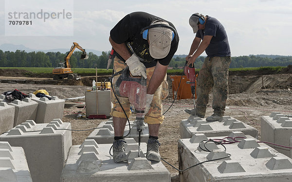 Bauarbeiter bohren Löcher in Steinblöcke  die anschließend f¸r eine Baugrund-Probebelastung verwendet werden sollen  auf einer Baustelle in Fridolfing  Bayern  Deutschland  Europa