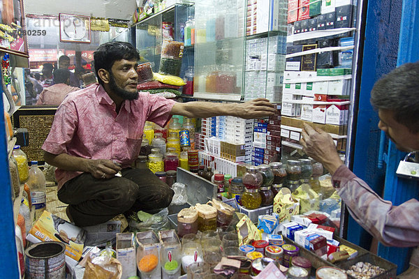 Kioskverkäufer reicht einem Kunden Zigarretten  Dhaka  Bangladesch  S¸dasien