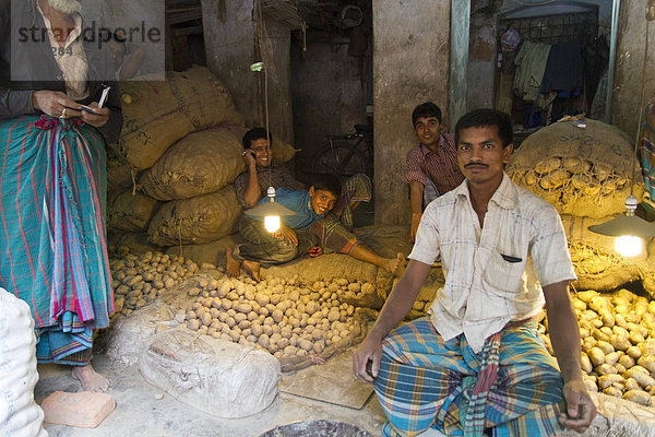Markthändler sitzen zwischen Kartoffeln und Jutesäcken  Gew¸rzmarkt  Old Dhaka  Dhaka  Bangladesch  S¸dasien