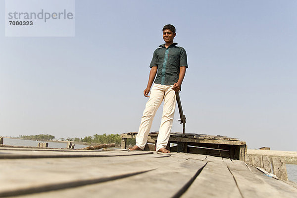 Junger Fährmann steuert sein Holzboot  Gabura  Sundabarns  Khulna District  Bangladesch  S¸dasien