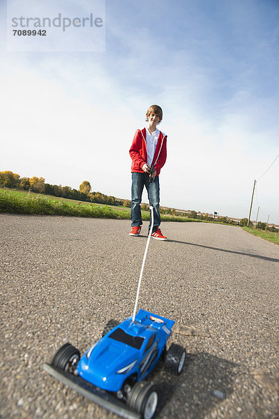 Jungen spielt mit ferngesteuertem Modellauto