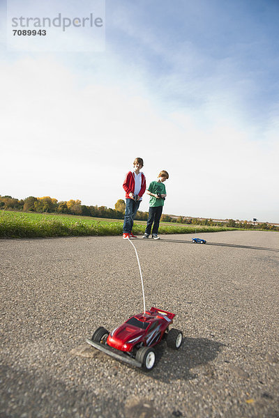 Zwei Jungen spielen mit ferngesteuertem Modellauto