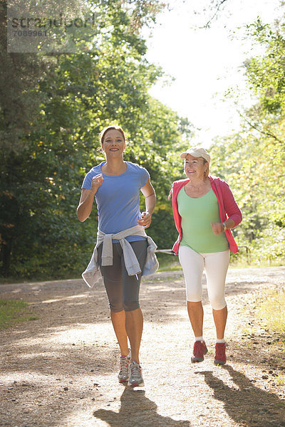 Zwei Frauen joggen auf einem Waldweg