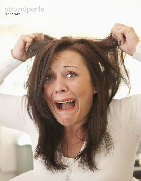 Junge Frau sorgt sich um zerzaustes Haar
