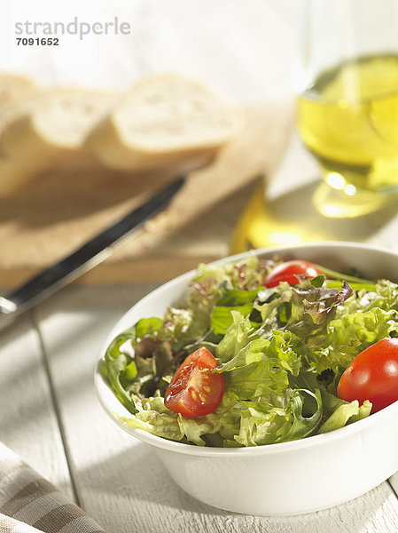 Gemischter Salat mit Brot und Olivenöl auf dem Tisch