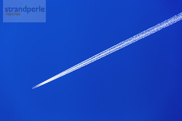 Österreich  Flugzeug mit Kondensstreifen gegen blauen Himmel