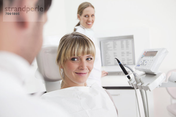 Germany  Dentist and patient in clinic  smiling