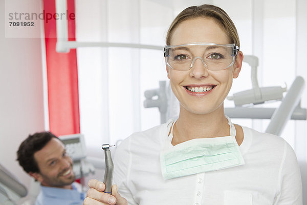 Germany  Dentist with safety glasses  patient in background