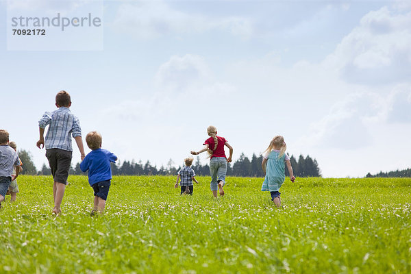 Germany  Bavaria  Group of children running through meadow