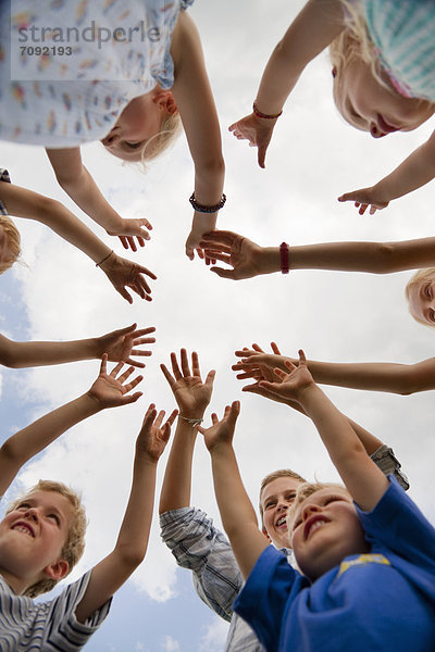 Germany  Bavaria  Group of children raising hands in air