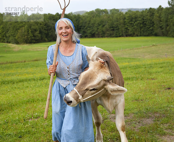 Mature woman with cow on farm