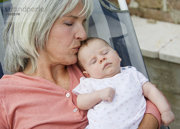 Frau mit Enkelkind entspannt im Liegestuhl  lächelnd