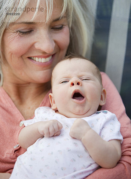 Woman with grandchild sitting in lawn chair  smiling