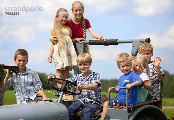 Deutschland  Bayern  Kindergruppe im alten Traktor sitzend