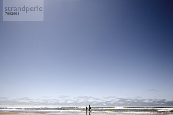 Frankreich  Zwei Jungen  die mit Body Surfboards am Strand spazieren gehen