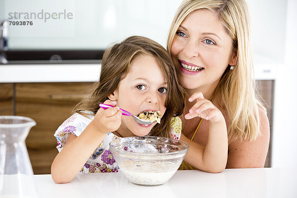 Germany  Daughter eating muesli in kitchen