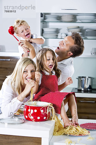 Deutschland  Familienspiel mit Spaghetti auf Küchenarbeitsplatte