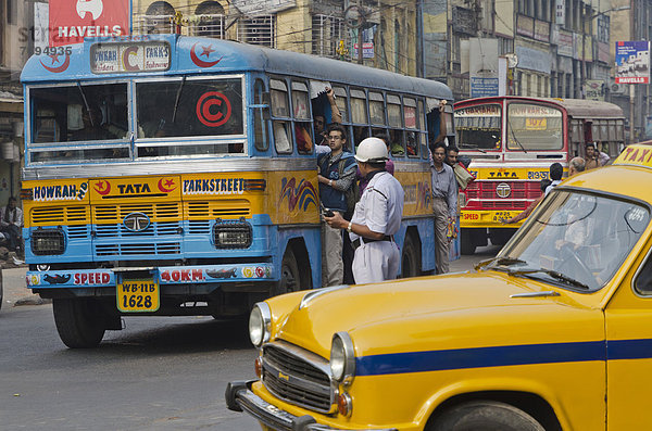Straßenszene mit Linienbus  Taxi und Polizisten  Kolkata  Kalkutta  Indien  Asien
