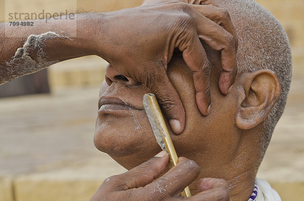 Der Kopf wird rasiert  Teil des Rituals um die Seele eines Verstorbenen zu verabschieden  an den Ghats von Varanasi  Indien  Asien
