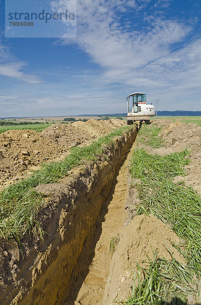 Bagger gräbt einen Graben durch ein landwirtschaftliches Gebiet  Laurich  Sachsen  Deutschland  Europa