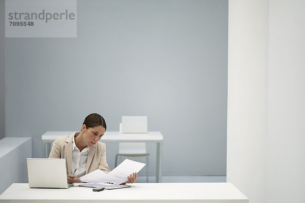 Geschäftsfrau beim Lesen von Dokumenten im Büro