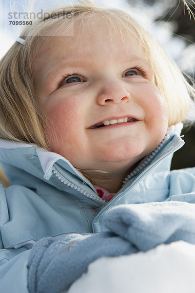Lächelndes Kleinkind Mädchen in Winterkleidung im Freien  Portrait