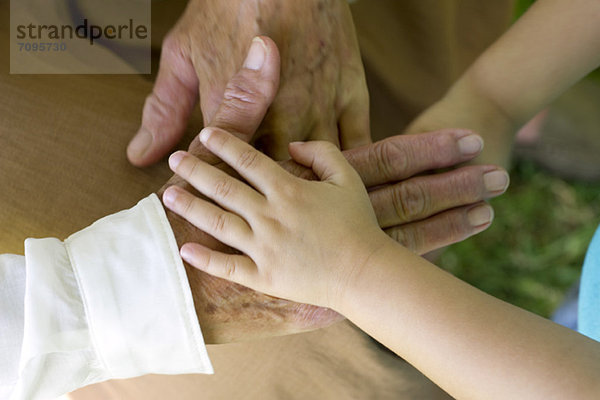 Kinderhand mit der Hand eines älteren Menschen
