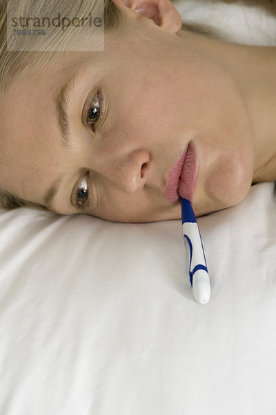 Junge Frau mit Thermometer im Mund  abgeschnitten