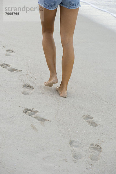 Frau  die am Strand spazieren geht  niedriger Abschnitt