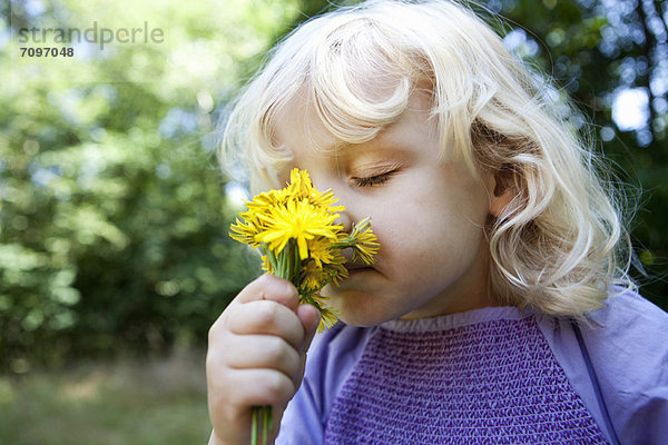 Mädchen riechende Wildblumen im Freien