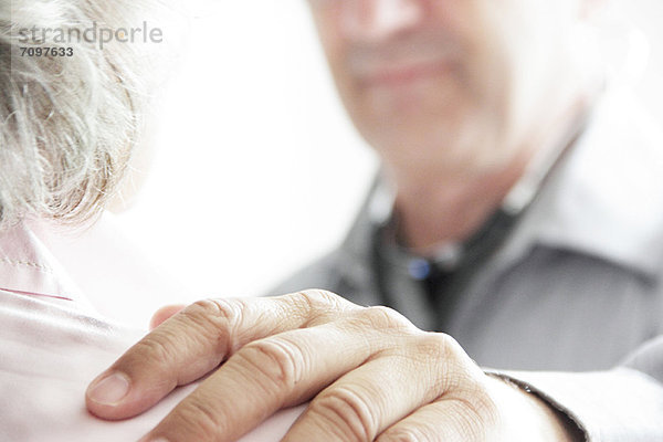 Arzt mit Hand auf der Schulter des Patienten