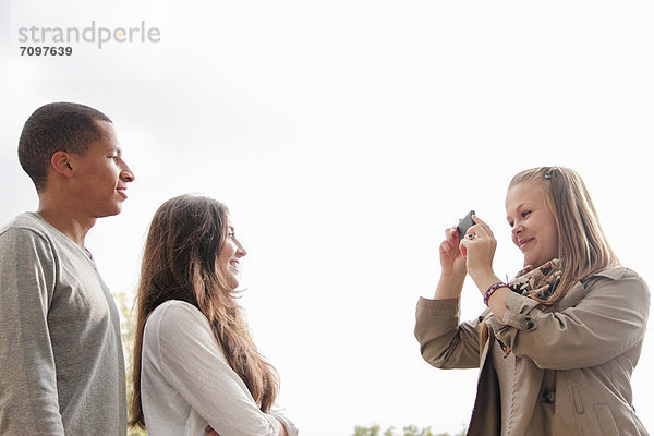 Teenagermädchen beim Fotografieren von Freunden