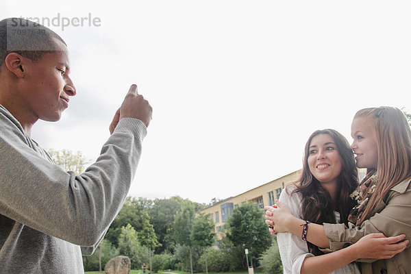 Teenager-Junge beim Fotografieren von Freunden