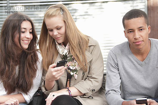 Jugendliche  die Mobiltelefone im Freien benutzen