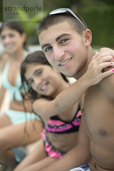 Bruder und Schwester beim Umarmen am Pool