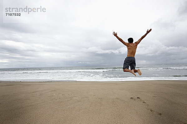 Mann  Fröhlichkeit  Strand  springen  jung