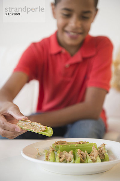 Junge - Person Hispanier Sellerie essen essend isst Erdnuss Butter