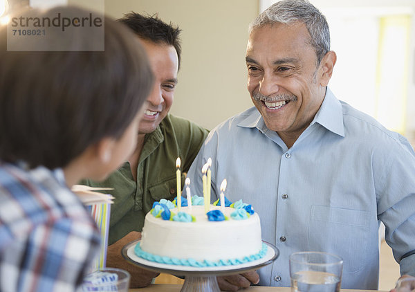 Hispanic grandfather  father and son celebrating birthday