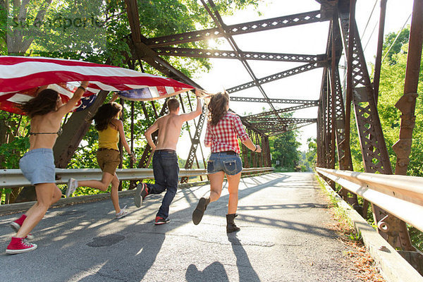 Gruppe von Freunden auf der Brücke mit amerikanischer Flagge