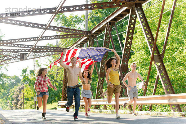 Gruppe von Freunden auf der Brücke mit amerikanischer Flagge