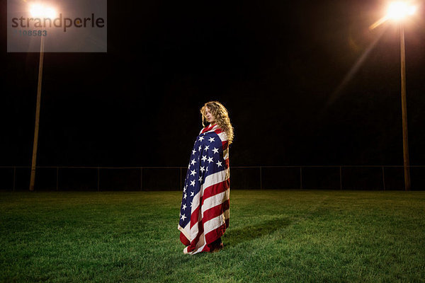 Mädchen in amerikanische Flagge gehüllt bei Nacht