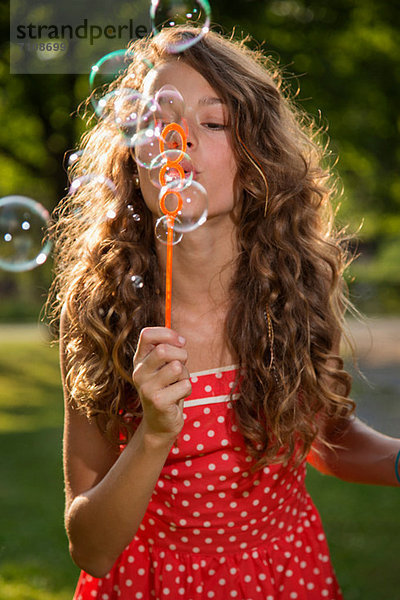 Mädchen bläst Blasen mit Blasenstab