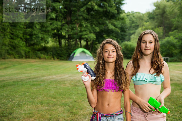 Porträt von zwei Mädchen mit Wasserpistolen